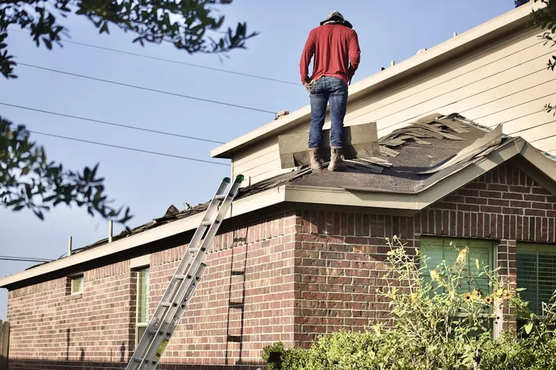 Professional roofer working on a residential roof in Quincy Center
